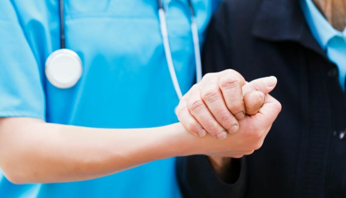 Nurse holding the hand of an elderly